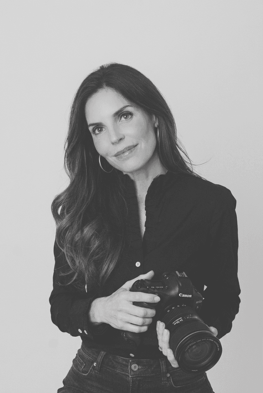 Jennie Slade holding her Canon camera, black and white portrait