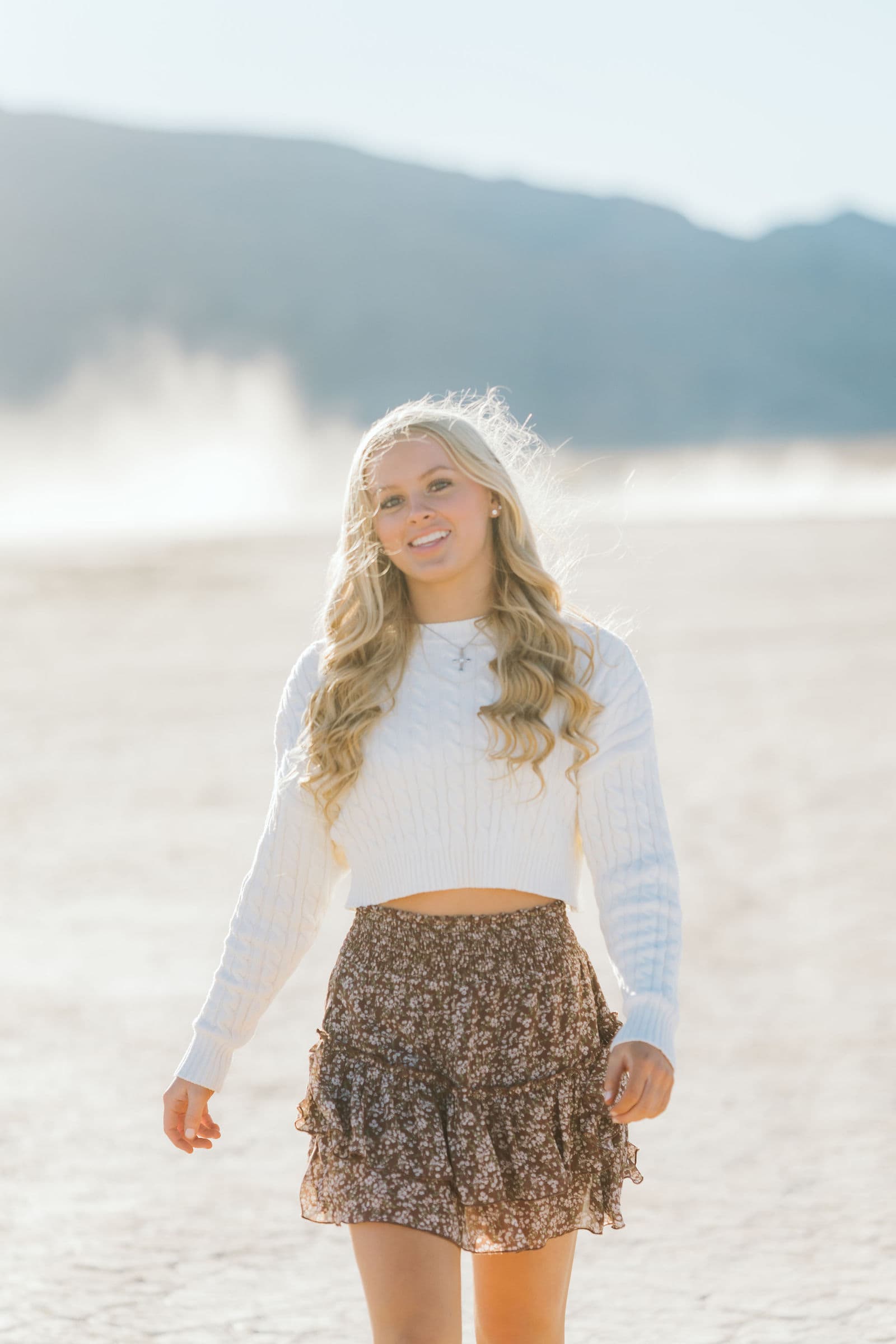 Senior blonde girl white sweater floral skirt at Dry Lake Bed