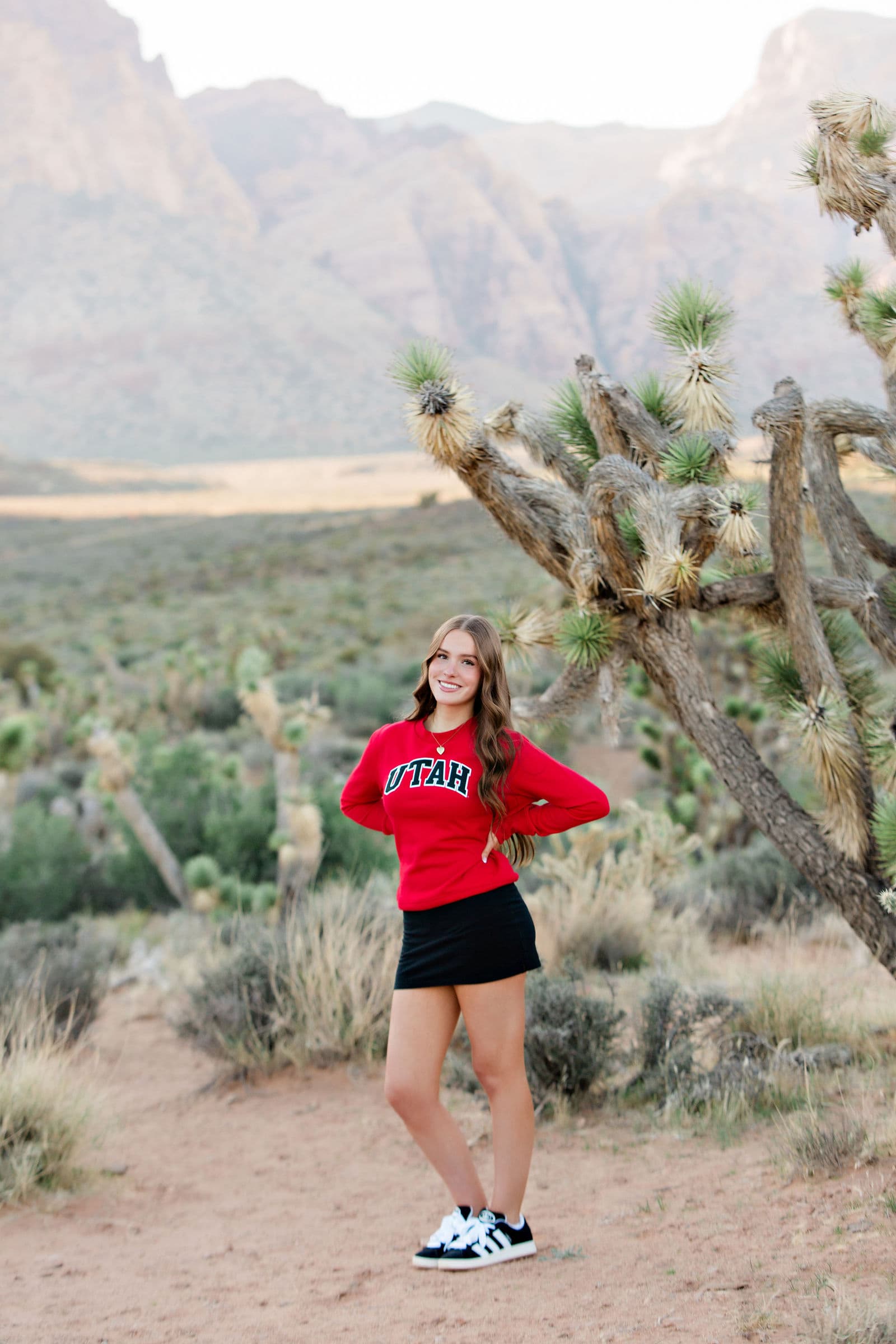 Senior in red Utah sweatshirt at Red Rock