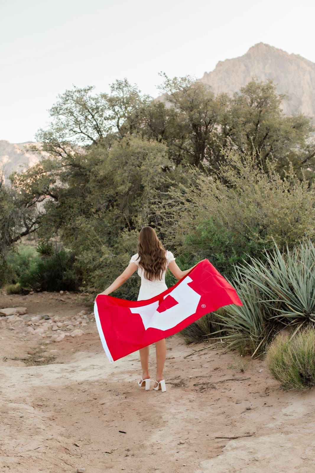 Senior girl with red Utah flag at Red Rock