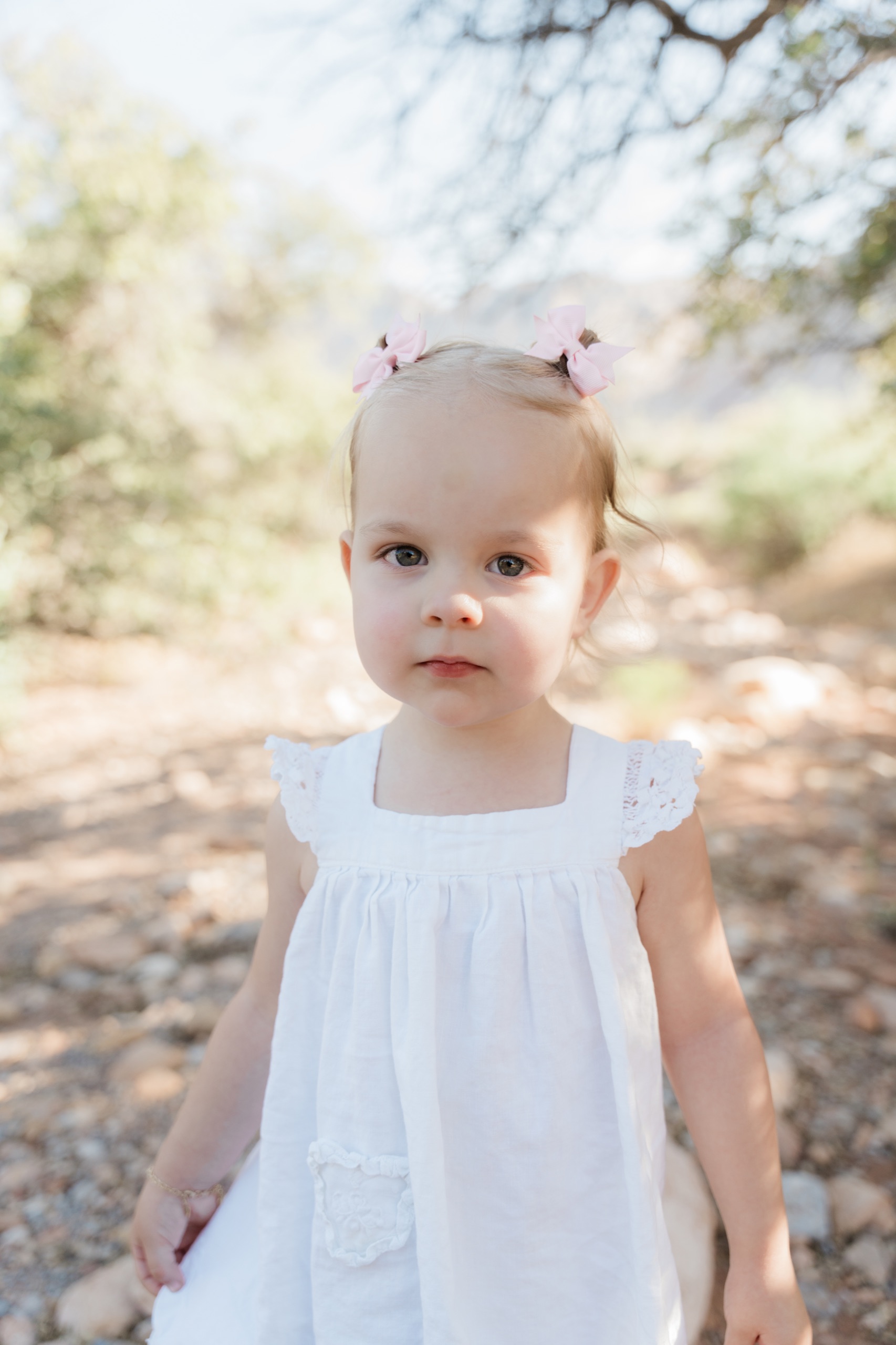 Toddler in a white dress with pink bows